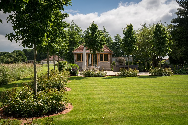 The brick edged beds have white pear trees underplanted with white roses